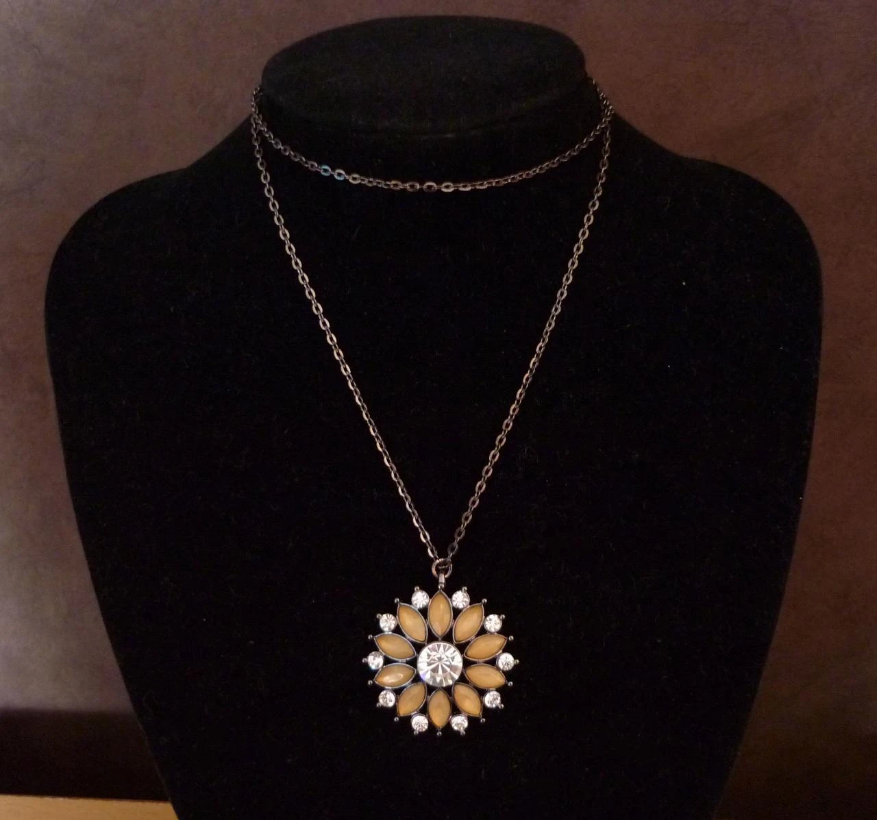 Antracietkleurige ketting met strass bloem hanger met beige stenen